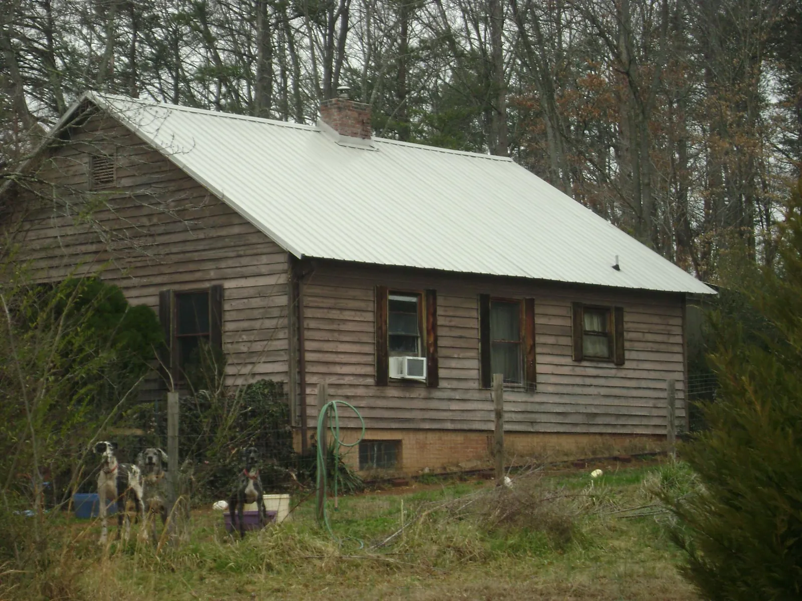 White metal roof on an old wood sided farmhouse, from a Metal Roof Installation job in Onemo